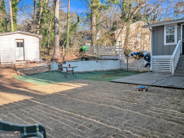 view of yard featuring an outbuilding, a shed, and fence