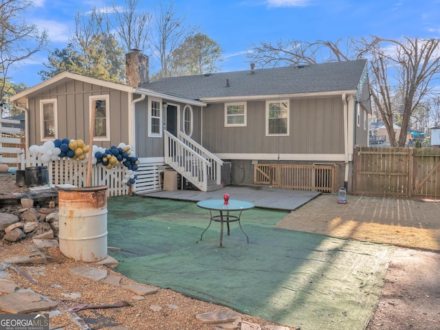 rear view of property with entry steps, a patio, a chimney, roof with shingles, and fence