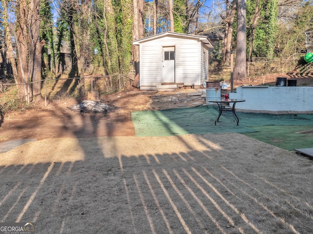 view of yard featuring an outbuilding, a shed, and fence