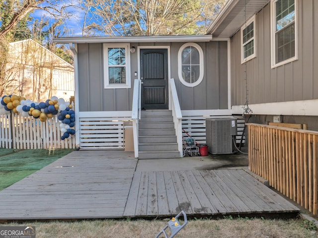 entrance to property with a wooden deck and central air condition unit