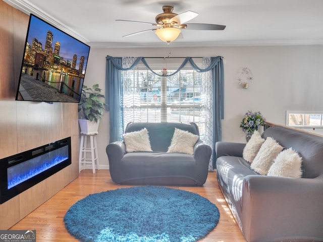 living room with a glass covered fireplace, crown molding, and wood finished floors