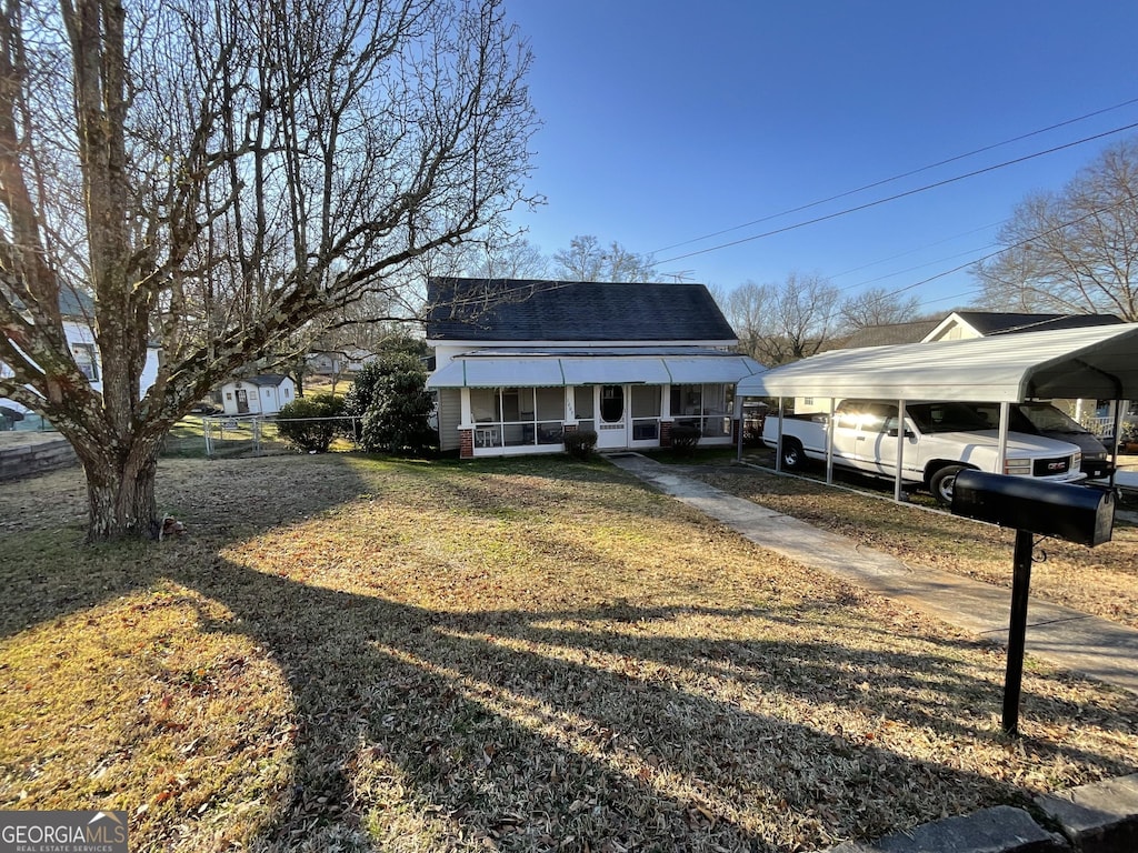 view of front of home with a porch, a carport, and a front lawn