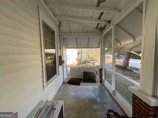 unfurnished sunroom featuring vaulted ceiling with beams