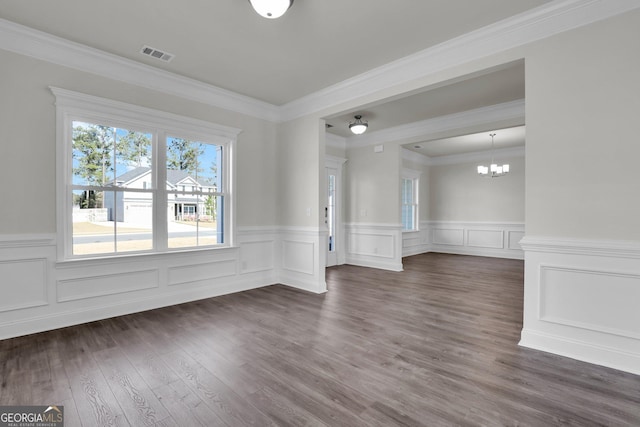 unfurnished room with dark wood finished floors, visible vents, an inviting chandelier, and ornamental molding