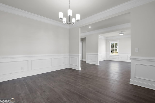 spare room with a notable chandelier, dark wood-style flooring, and crown molding