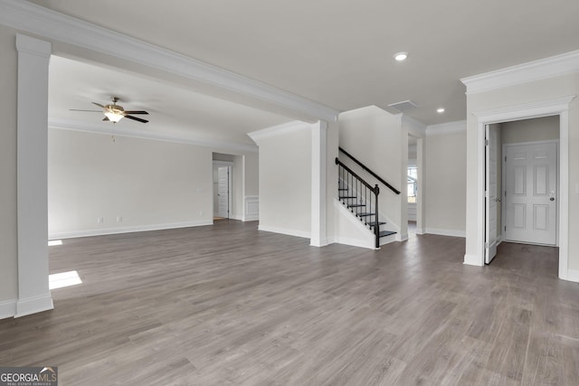 unfurnished living room featuring wood finished floors, visible vents, baseboards, ornamental molding, and stairs