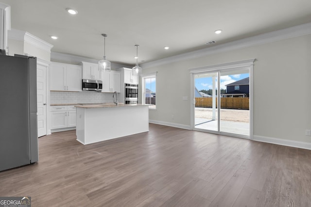 kitchen featuring decorative backsplash, crown molding, visible vents, and stainless steel appliances