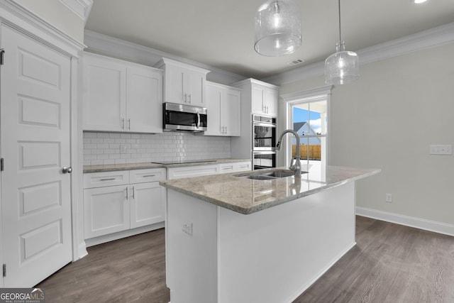 kitchen featuring visible vents, backsplash, crown molding, appliances with stainless steel finishes, and a sink