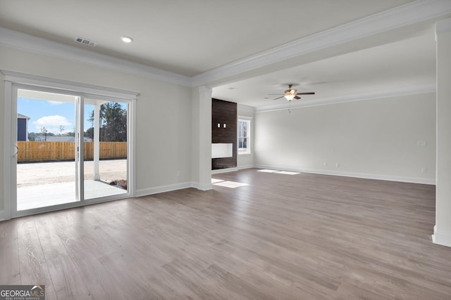 unfurnished living room featuring visible vents, wood finished floors, a large fireplace, crown molding, and baseboards