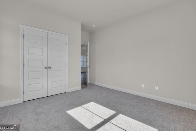 unfurnished bedroom featuring a closet, carpet flooring, and baseboards