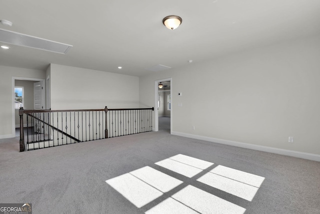 carpeted empty room featuring recessed lighting, baseboards, and attic access