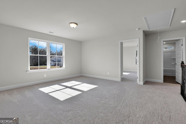 unfurnished bedroom featuring visible vents, attic access, baseboards, and carpet floors