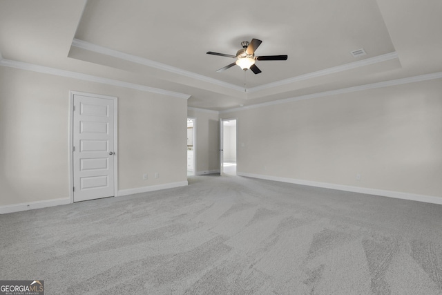 interior space with a tray ceiling, baseboards, visible vents, and a ceiling fan