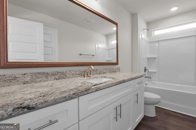 full bath featuring visible vents, toilet, bathtub / shower combination, wood finished floors, and vanity