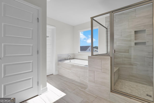 bathroom featuring a bath and a stall shower