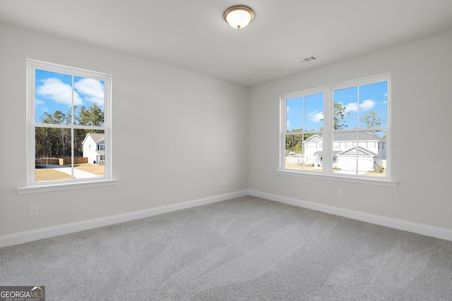 unfurnished room with visible vents, baseboards, and carpet