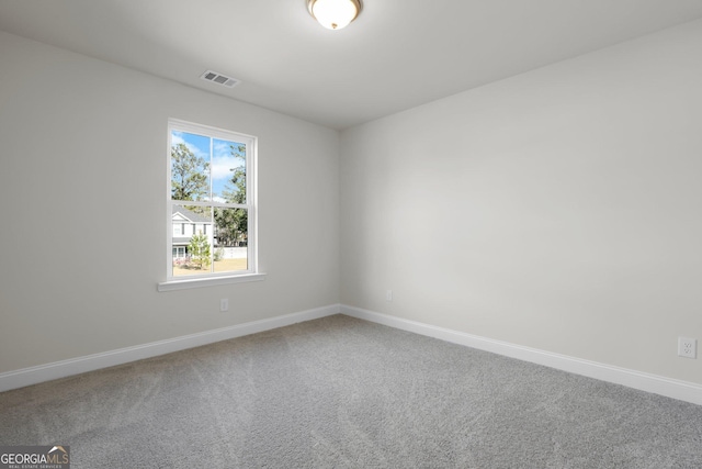 carpeted spare room with visible vents and baseboards