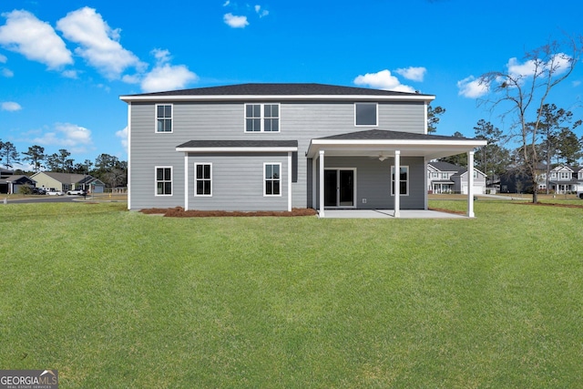 rear view of house with a patio, a lawn, and a ceiling fan