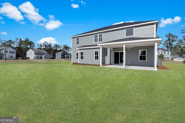 back of property with a lawn, a ceiling fan, and a patio area