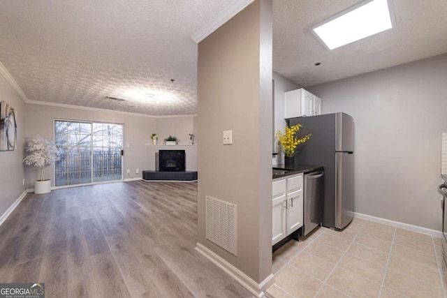 kitchen with white cabinetry, ornamental molding, and dishwasher