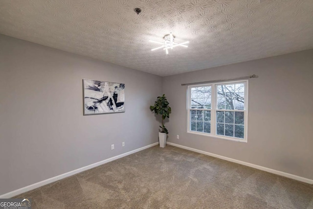 carpeted empty room with a textured ceiling