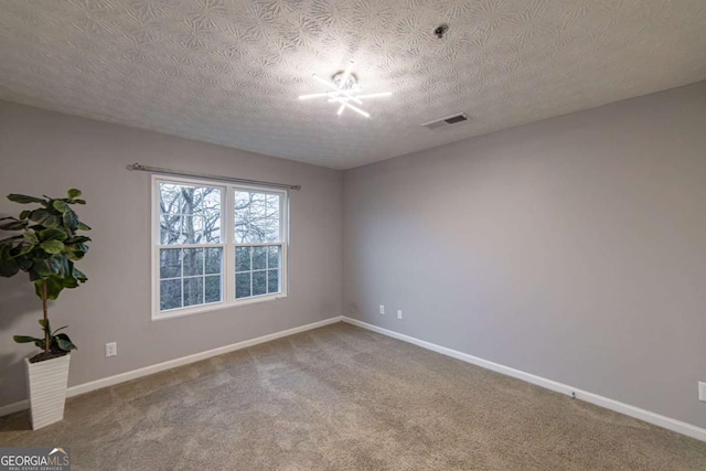 spare room featuring carpet floors and a textured ceiling