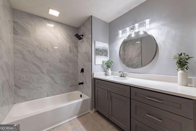 bathroom featuring tiled shower / bath, a textured ceiling, vanity, and tile patterned floors