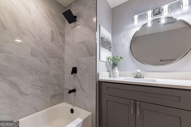 bathroom with tiled shower / bath combo and vanity