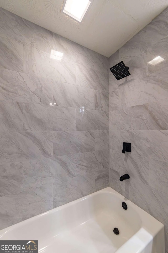 bathroom with tiled shower / bath combo