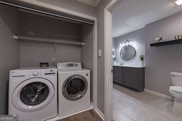 washroom featuring light tile patterned floors, a textured ceiling, and washing machine and clothes dryer