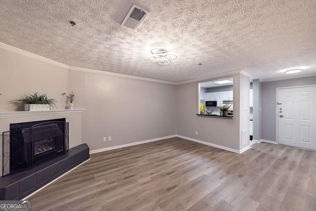 unfurnished living room featuring hardwood / wood-style flooring, a fireplace, and ornamental molding