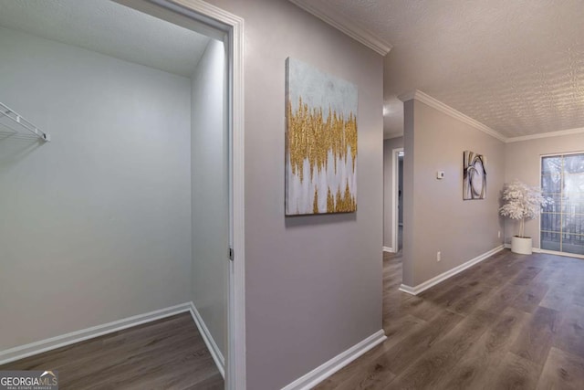 hallway featuring ornamental molding, dark hardwood / wood-style floors, and a textured ceiling