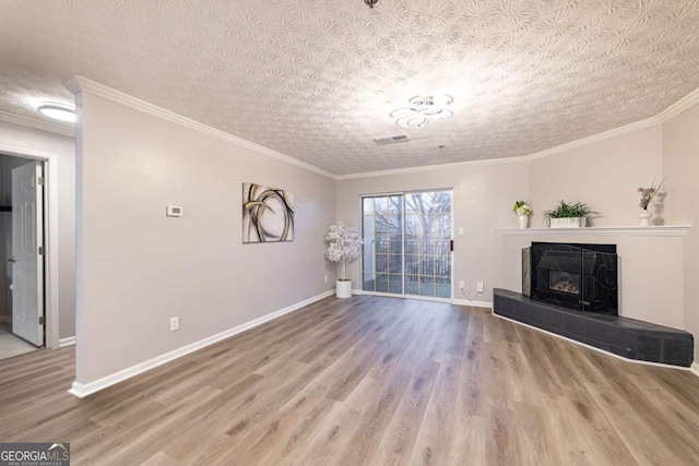 unfurnished living room with a tile fireplace, hardwood / wood-style floors, a textured ceiling, and crown molding