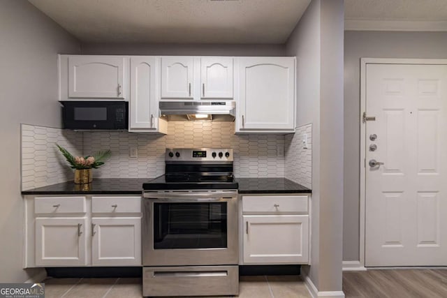 kitchen featuring electric stove, white cabinetry, dark stone counters, and tasteful backsplash