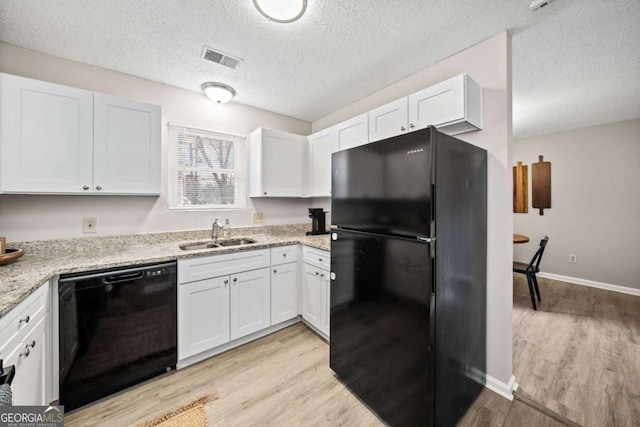 kitchen featuring sink, light stone counters, black appliances, white cabinets, and light wood-type flooring