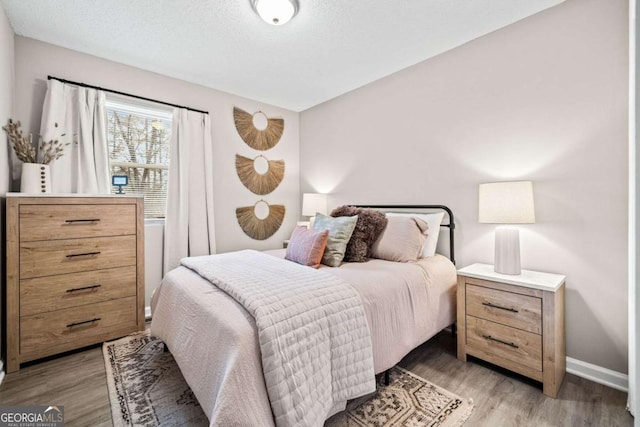 bedroom featuring a textured ceiling and light wood-type flooring