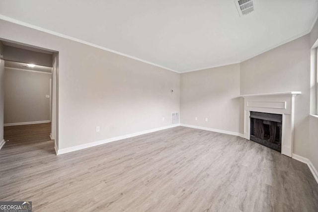 unfurnished living room with crown molding and light hardwood / wood-style flooring