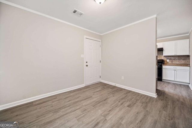 unfurnished room featuring hardwood / wood-style floors and crown molding