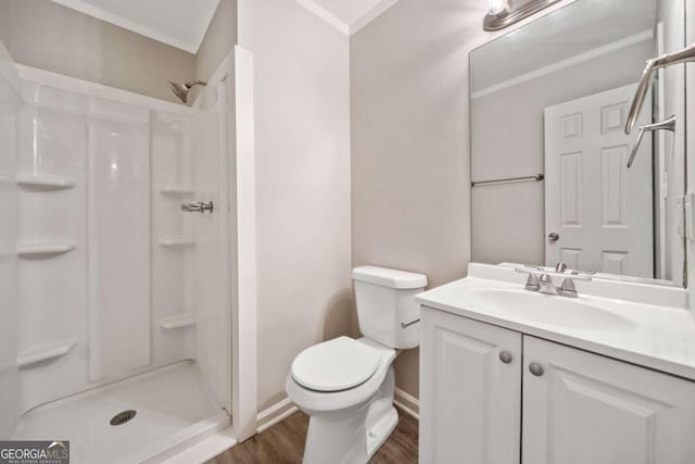 bathroom with hardwood / wood-style flooring, crown molding, vanity, toilet, and walk in shower