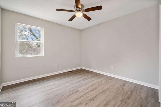 spare room featuring ceiling fan, wood-type flooring, and a textured ceiling