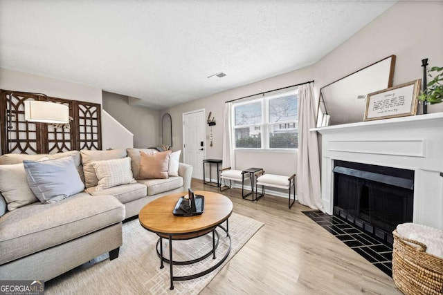 living room featuring wood-type flooring and a textured ceiling