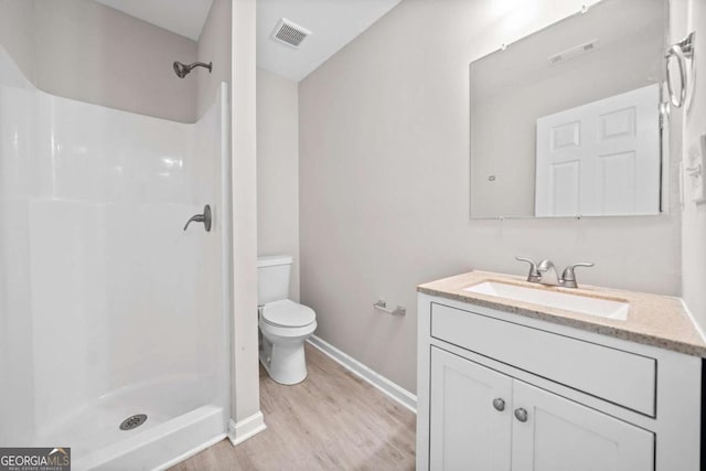 bathroom with walk in shower, vanity, toilet, and wood-type flooring