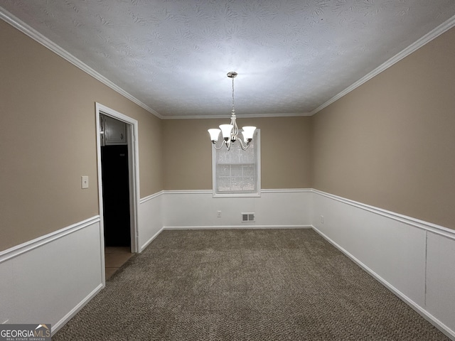 spare room with a notable chandelier, dark carpet, ornamental molding, and a textured ceiling