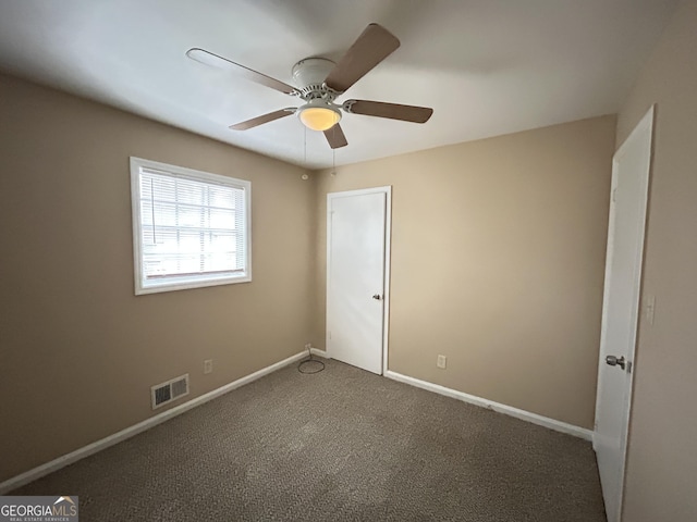 carpeted spare room with ceiling fan