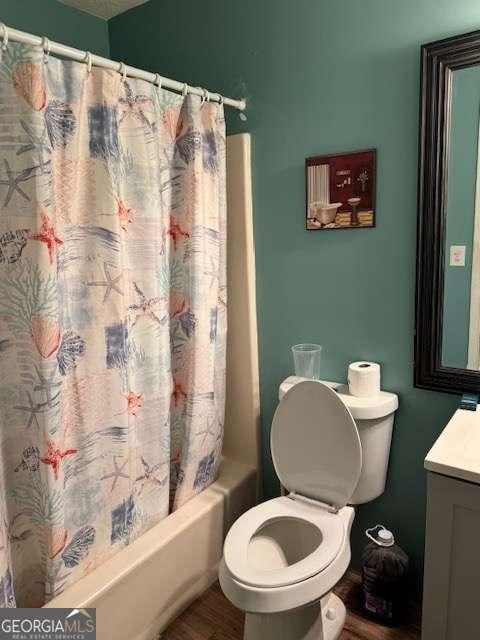 full bathroom with hardwood / wood-style flooring, vanity, shower / bath combo, and toilet