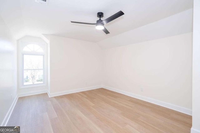 spare room with vaulted ceiling, light hardwood / wood-style floors, and ceiling fan