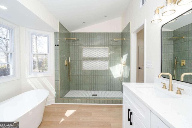 bathroom featuring shower with separate bathtub, lofted ceiling, hardwood / wood-style floors, and vanity