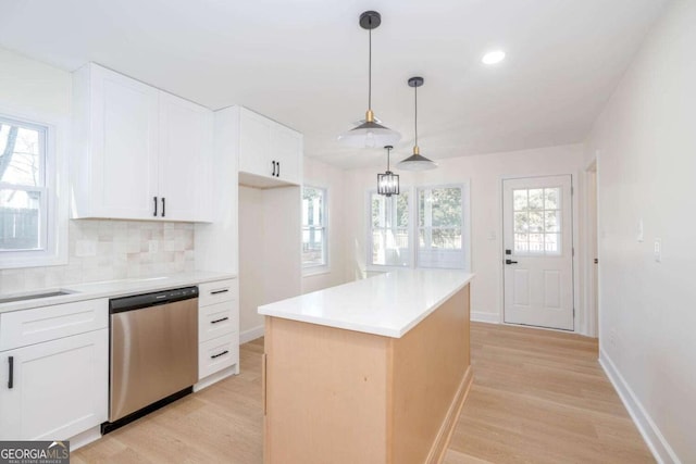 kitchen featuring dishwasher, hanging light fixtures, white cabinets, a kitchen island, and light wood-type flooring