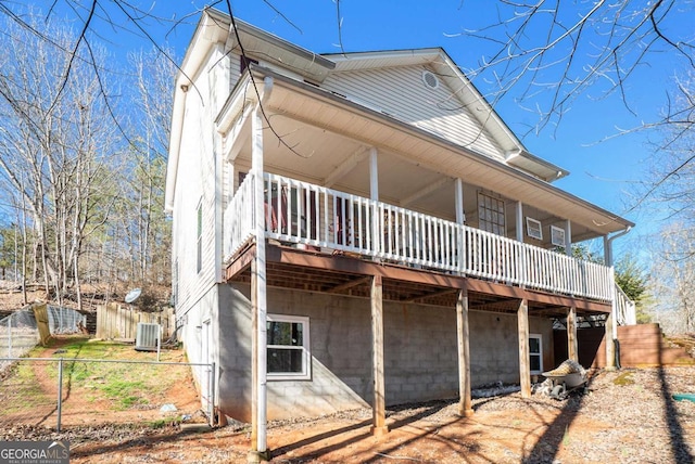 rear view of property with fence and central AC unit