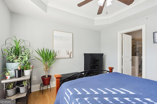 bedroom with ensuite bathroom, crown molding, a tray ceiling, ceiling fan, and hardwood / wood-style floors